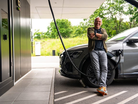 A man leans against his vehicle while it is being loaded