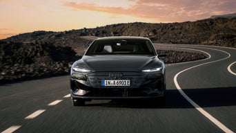 Black Audi A6 Avant e-tron from the front while driving on a rockside road