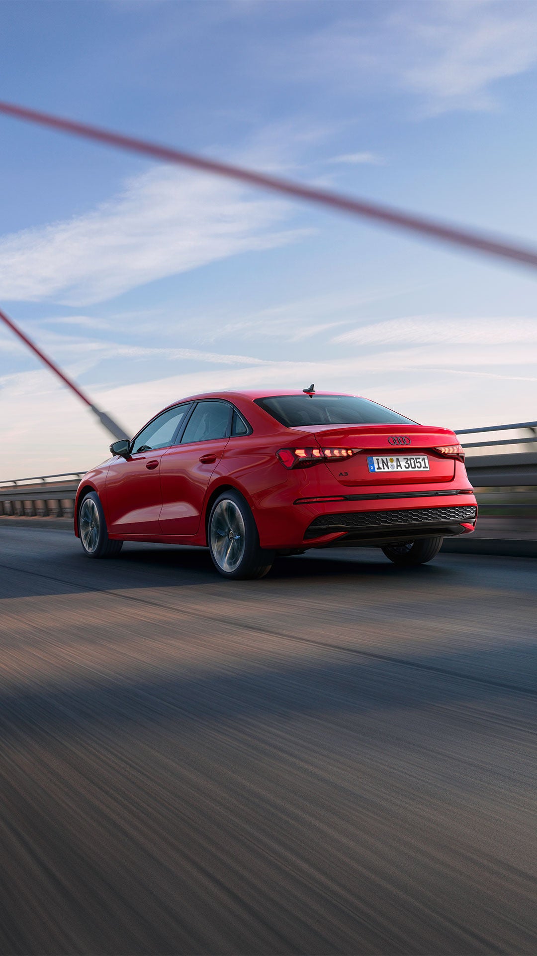 audi A3 Sedan rojo pasando por un puente