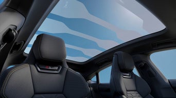Interior view of a car with luxury seats and a large panoramic sunroof.