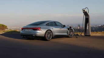 A grey e-tron GT parked and plugged into an EV charger
