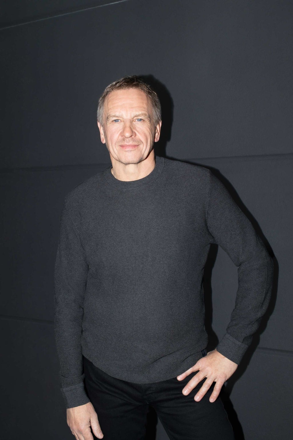 Portretfoto van Richard Spielberger, module-ontwikkelaar bij Audi. Spielberger houdt een hand op zijn heup en staat voor een donkere achtergrond.