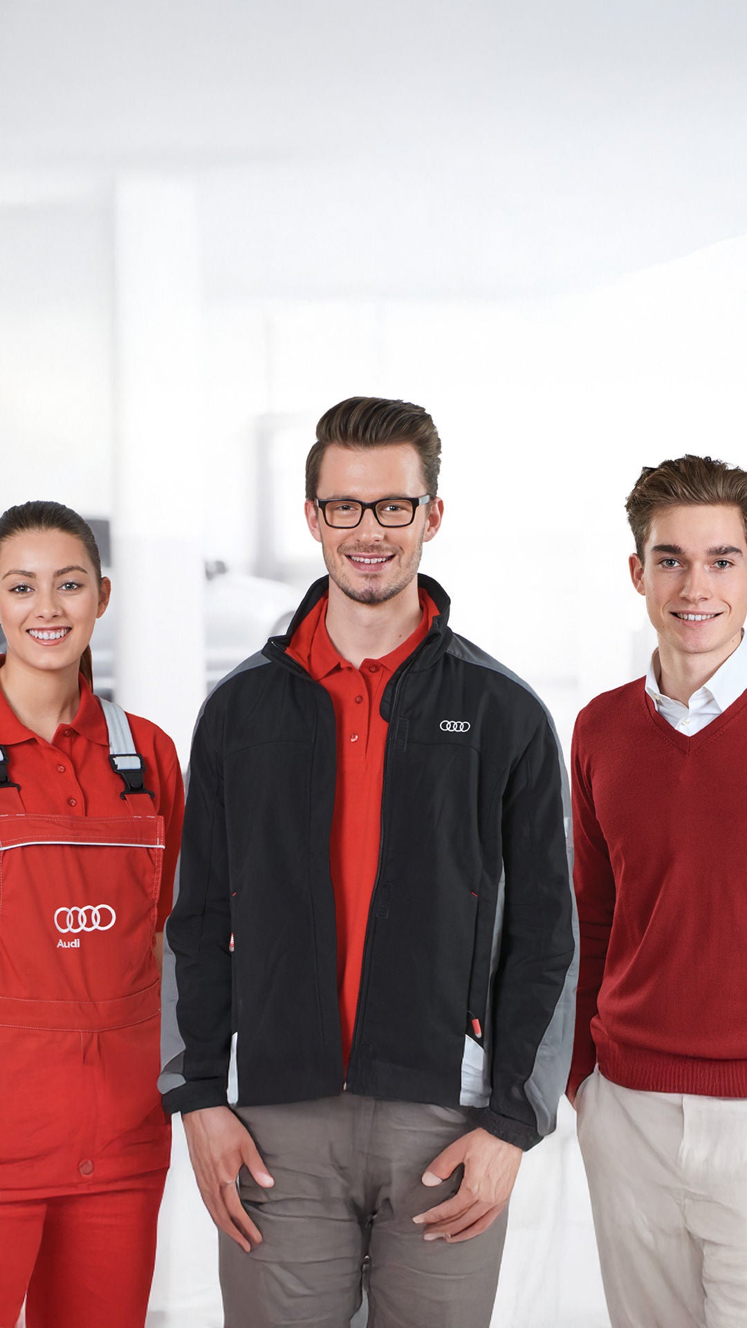 Zwei Auszubildende und ein Ausbilder stehen nebeneinander