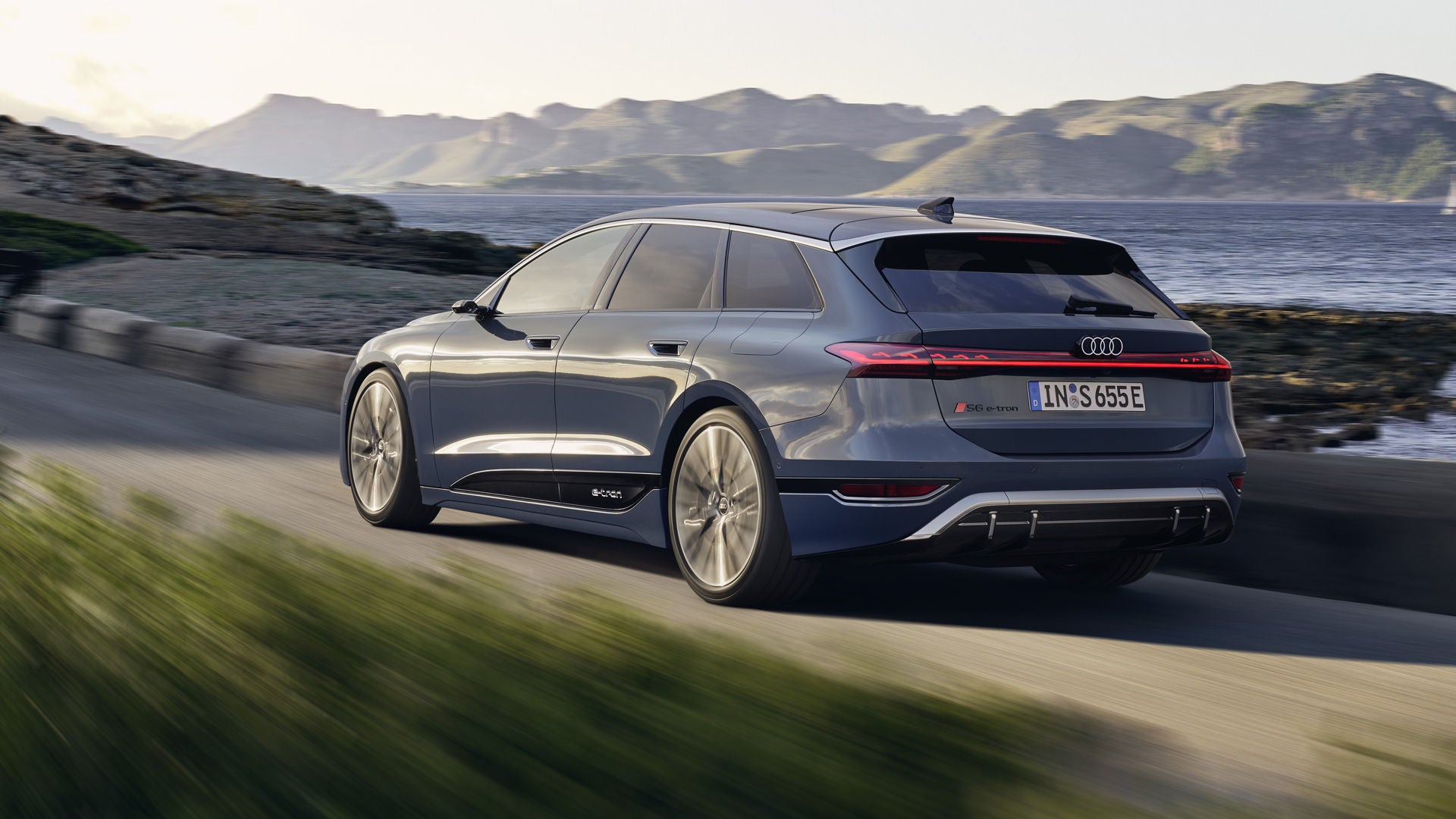 S6 Avant e-tron voor een bocht in de weg in een heuvellandschap.