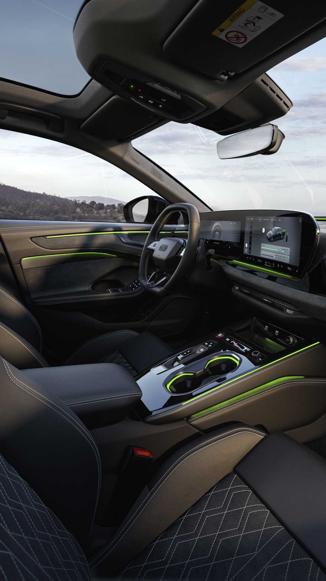 Das Cockpit der A6 Limousine e-hybrid aus Beifahrerperspektive. Der Fokus liegt dabei auf dem Lenkrad sowie den Panorama-Displays und dem grünen Ambiente-Licht.