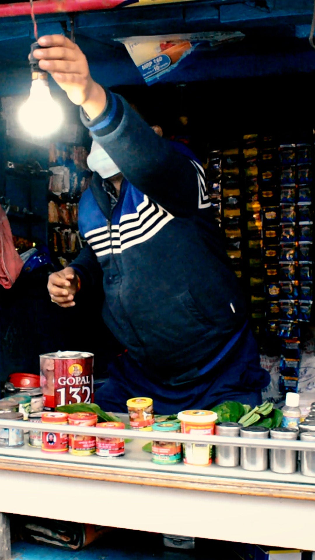 Man standing at a market stall. A light bulb lights up.