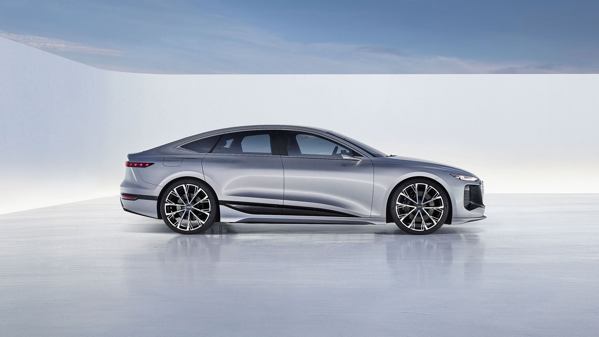 Silberne Audi-Studie mit elegantem, aerodynamischem Design in heller Studio-Umgebung, Seitenansicht.