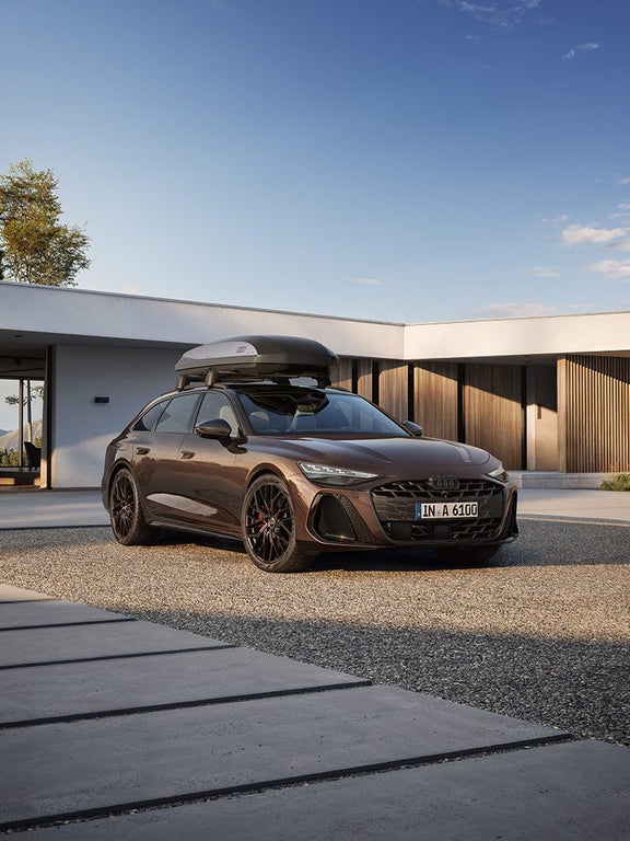 Audi A6 Avant side view with the roof box and family