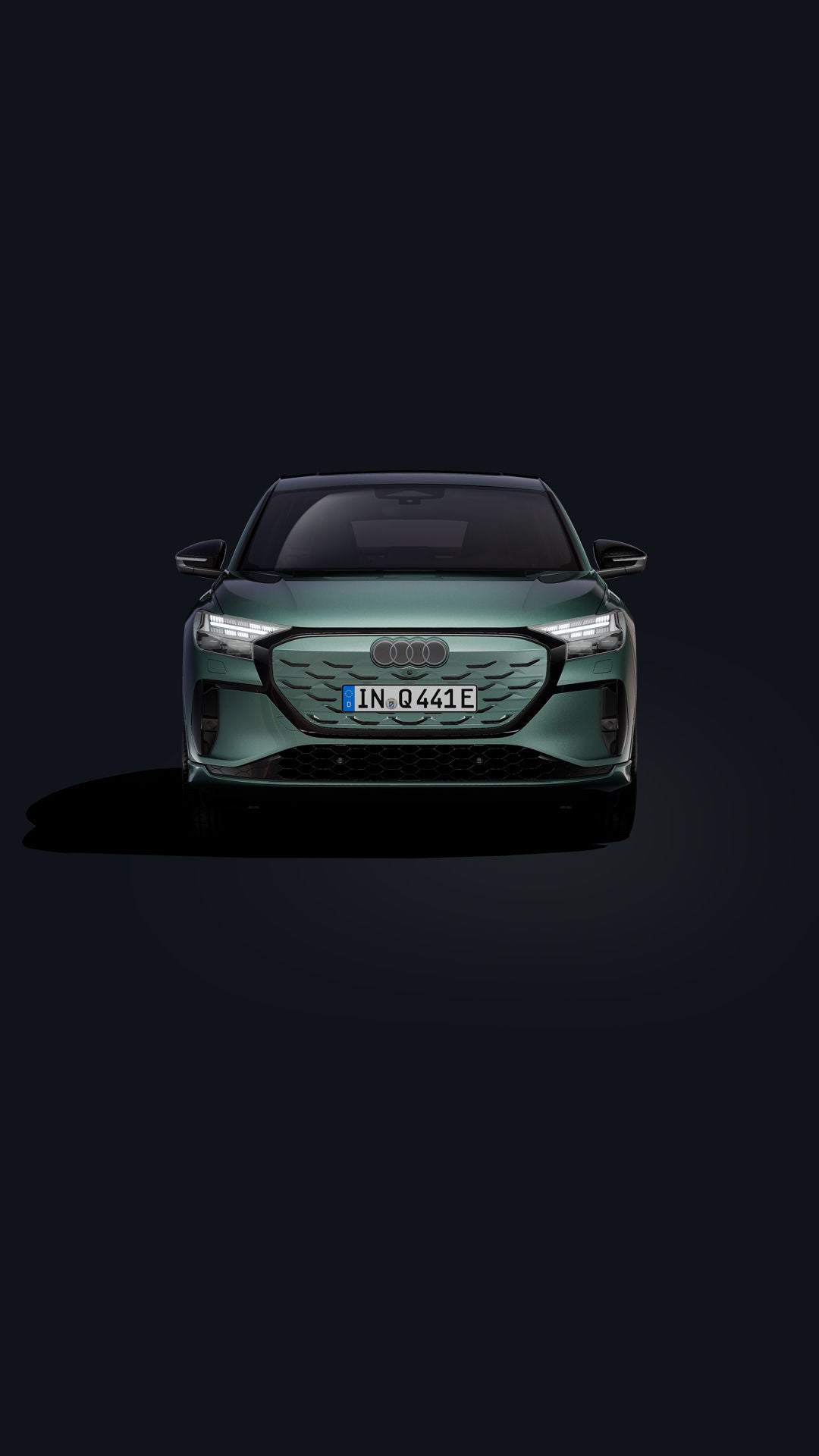 Der Q4 Sportback e-tron in Frontansicht auf dunklem Hintergrund stehend.