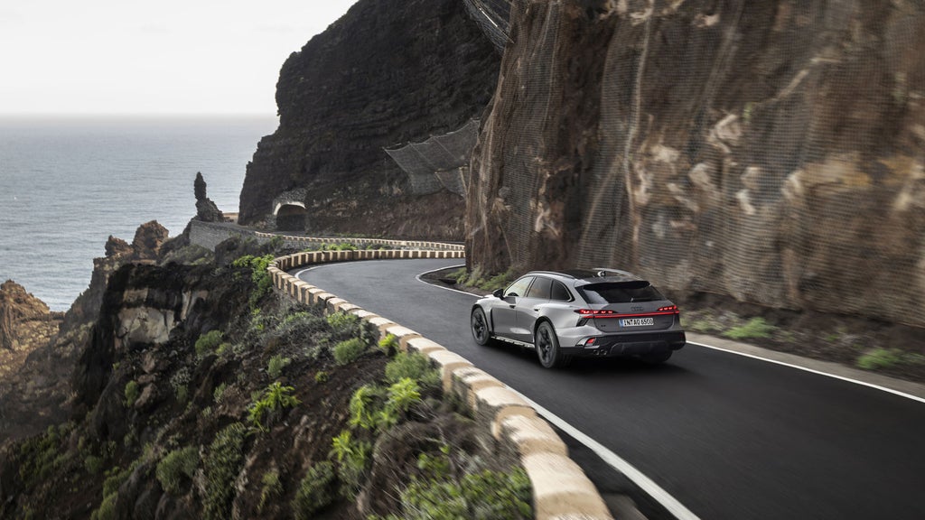 The new Audi A6 allroad driving on a road towards the coast