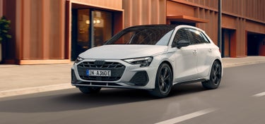 Een rijdende Audi A3 Sportback TFSI e van opzij gezien