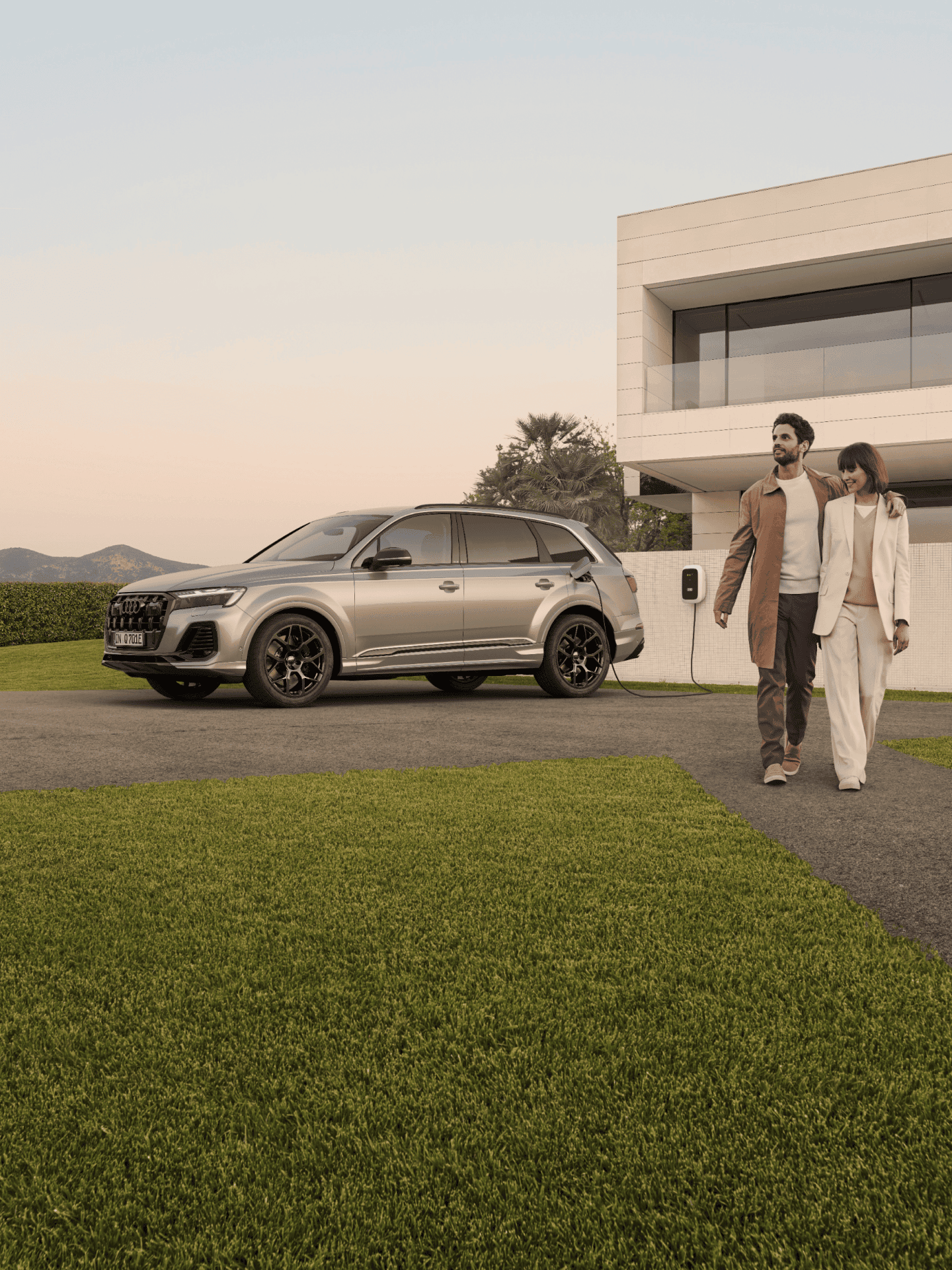 SUV parked outside a modern house with two people walking and holding hands.