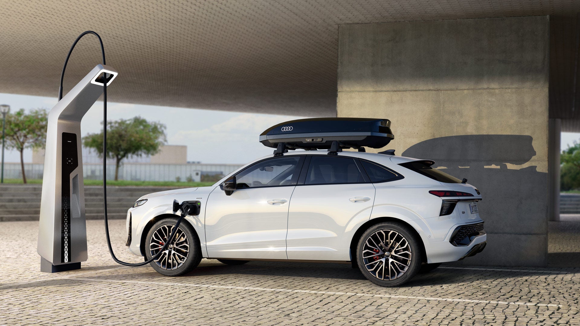 Q3 Sportback e-hybrid står vid en laddstation.