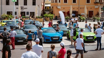 Viele Menschen laufen zwischen ausgestellten Audi Modellen herum