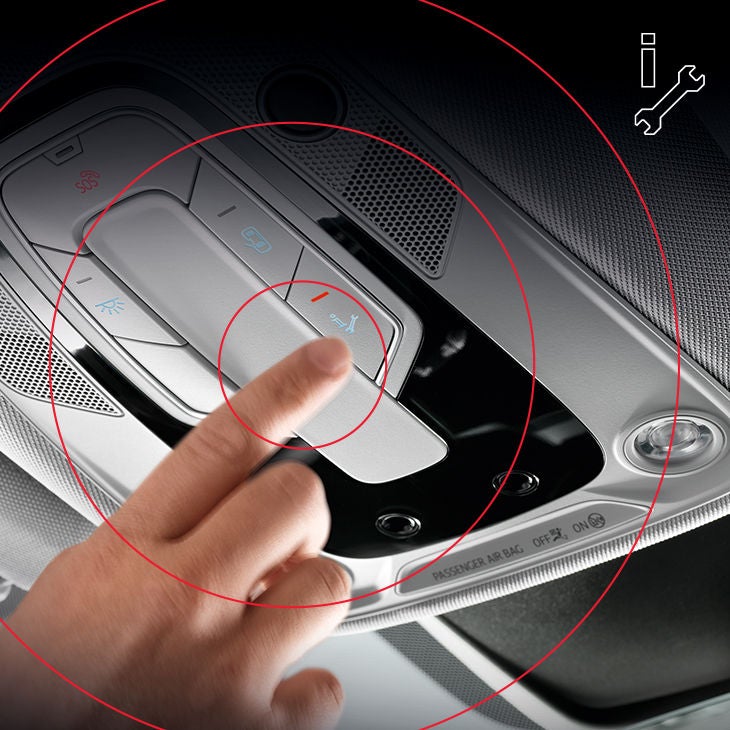 Ein Finger drückt im Audi die Service-Call-Taste im Dachbedienteil