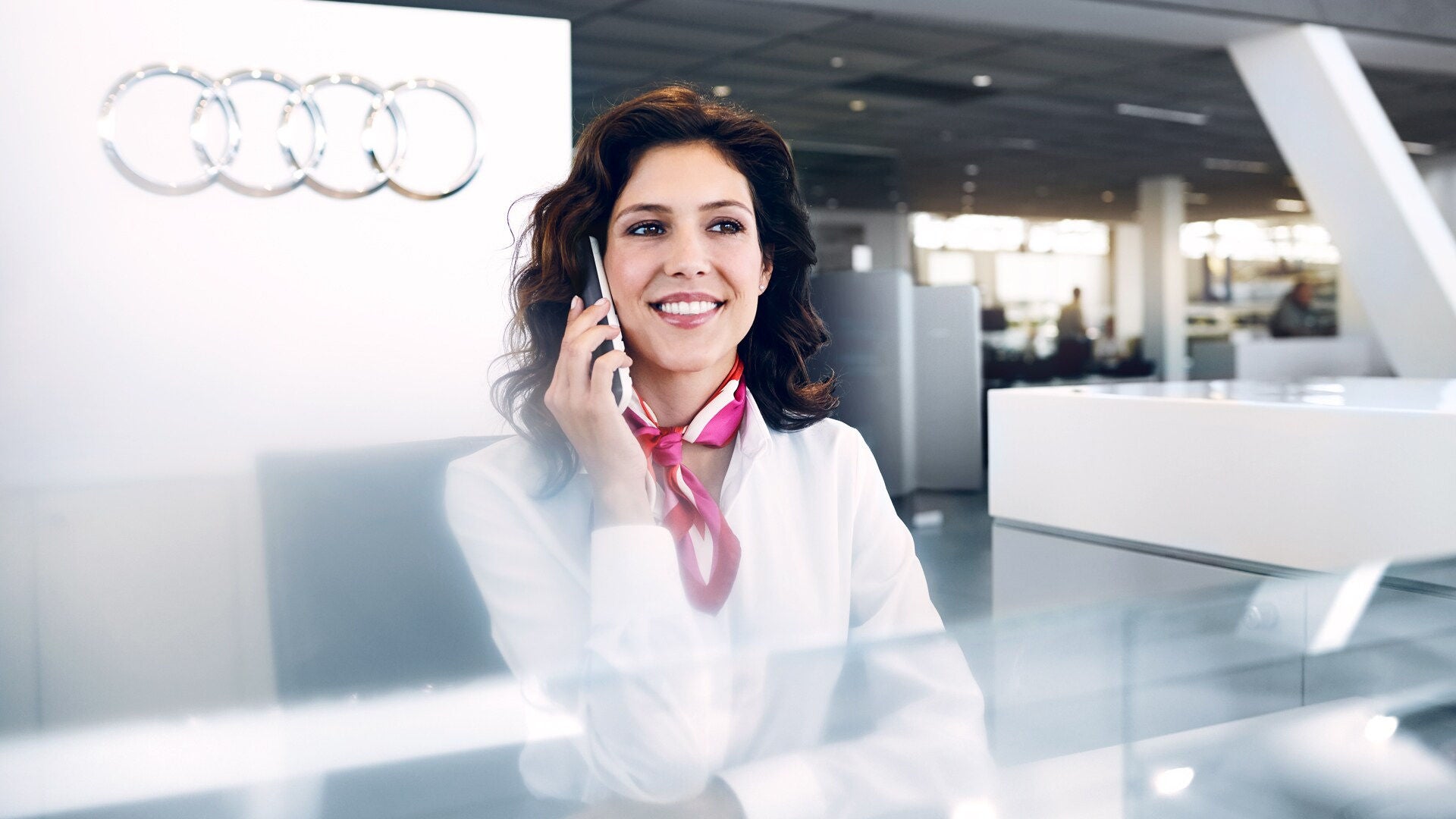 Eine Frau telefoniert in einem Audi Zentrum