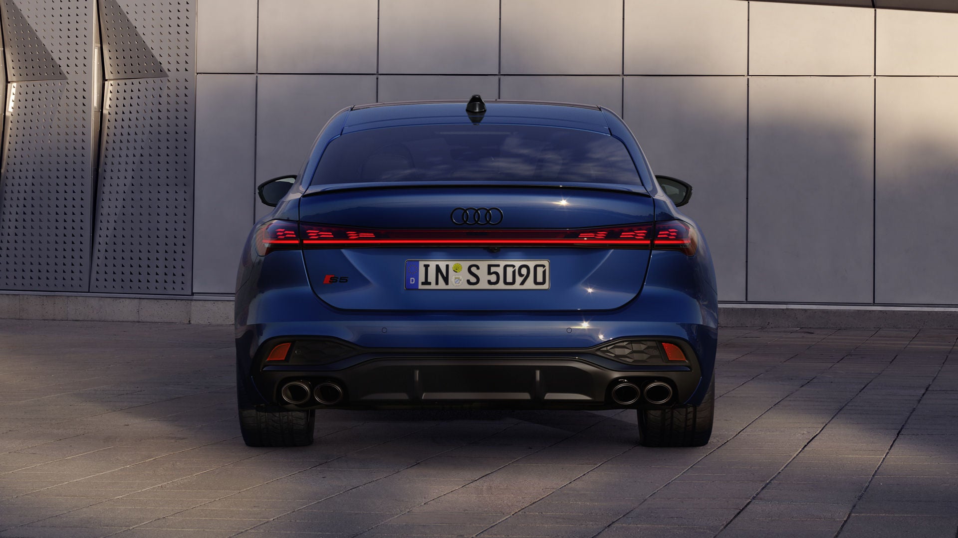 Heckansicht der S5 Limousine, welche vor einer Gebäudefassade steht.