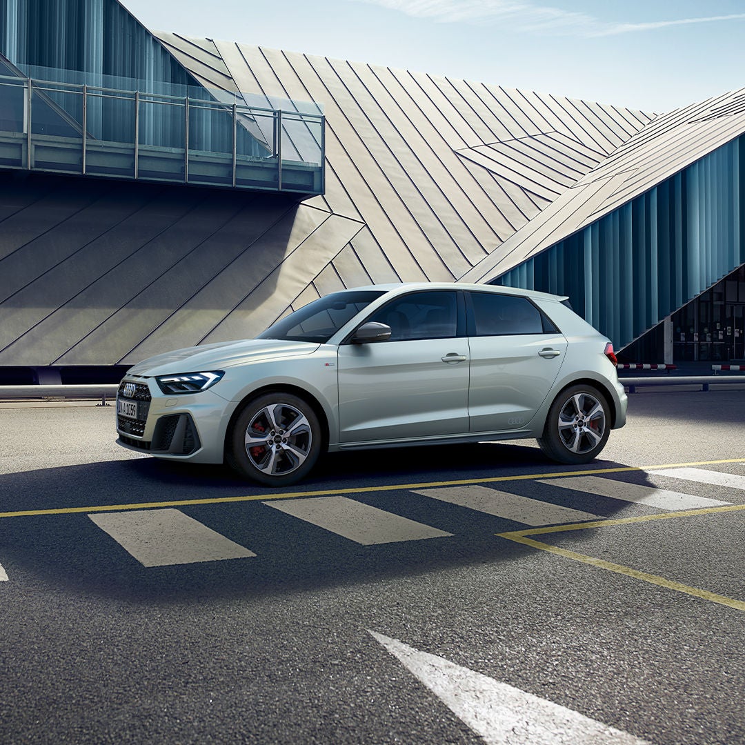 Rear view of an Audi car with a red wall background