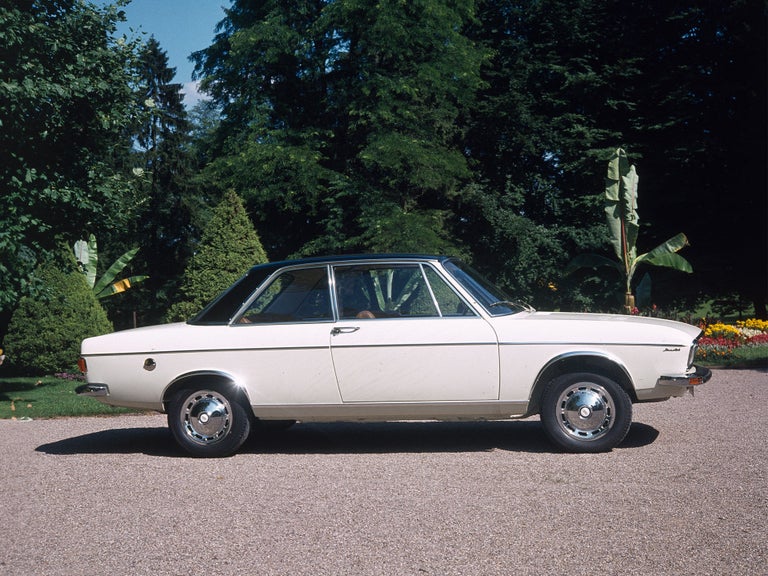 Audi 100 LS in weiß-schwarz in der Seitenansicht vor Palmen und Bäumen