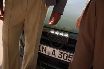 A 2024 Audi Q7 parked, framed by tranquil water in the background, exemplifying sophistication amidst a coastal landscape.