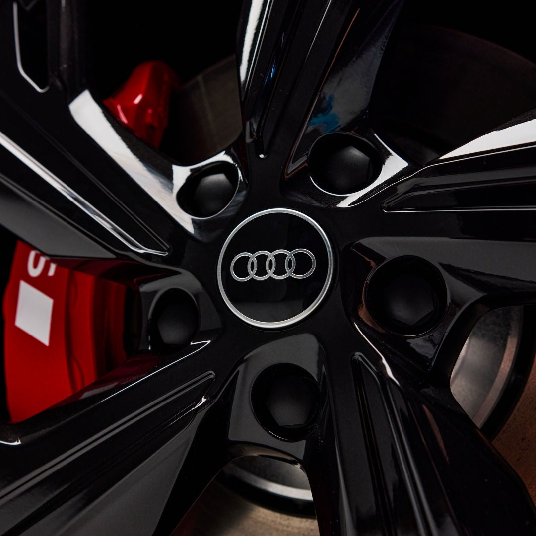 Close shot of black Audi rims with the logo on