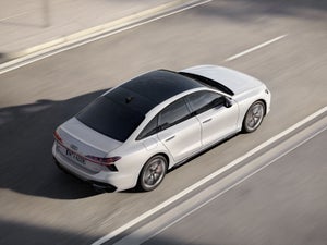 Een witte Audi A6 Limousine e-hybrid op de snelweg.