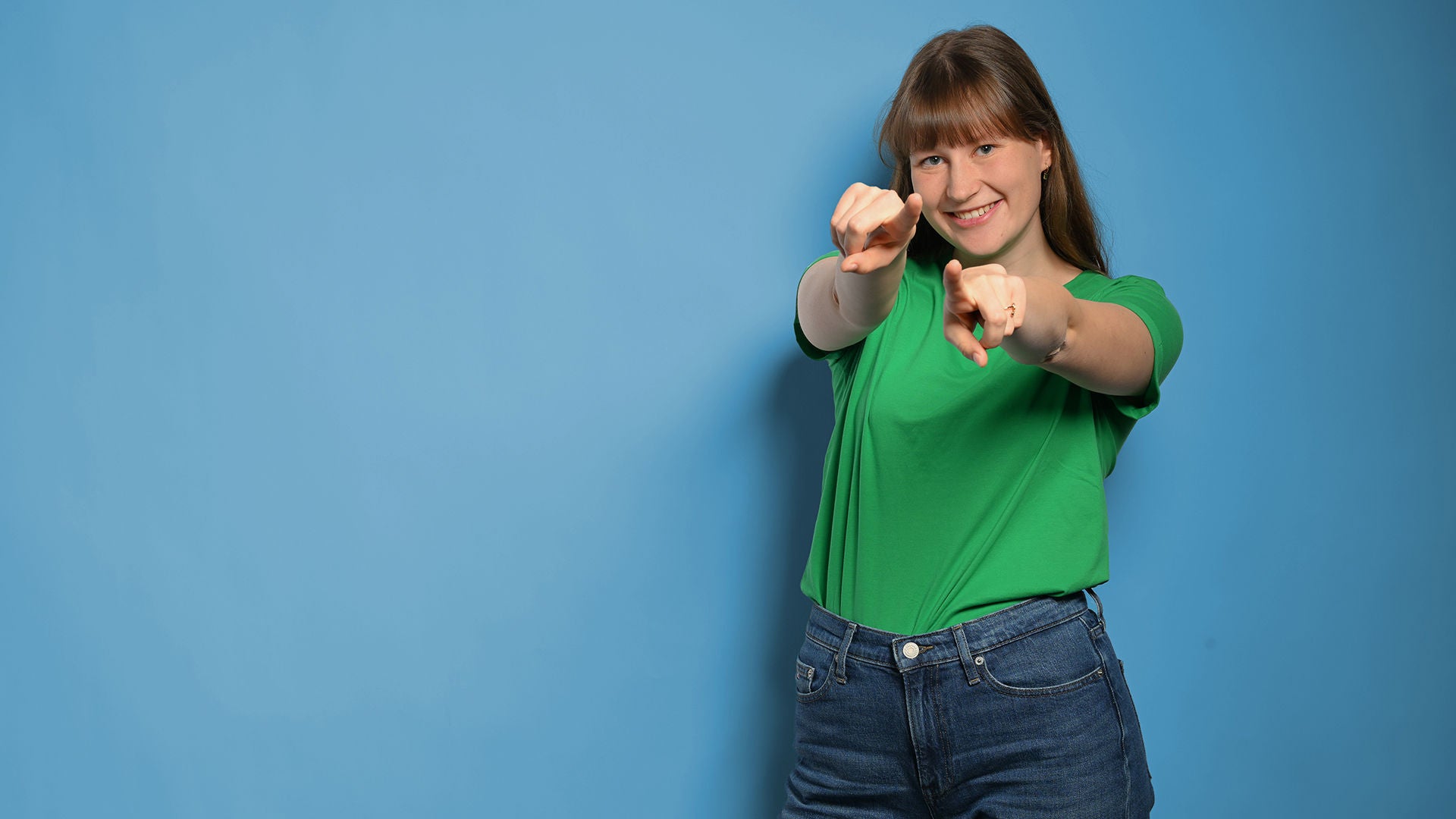 Josee zeigt auf die Kamera mit beiden Händen