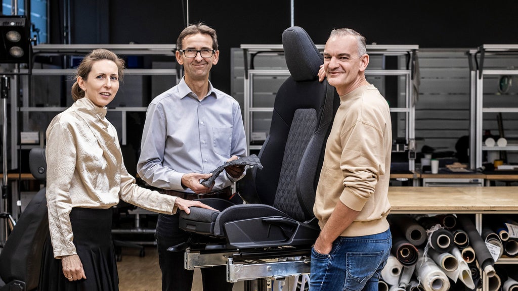 Christine Maier, Jürgen Frank and Günther Ernst in front of an audi car seat
