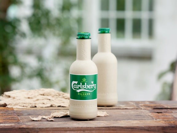 A green fibre bottle on a table.
