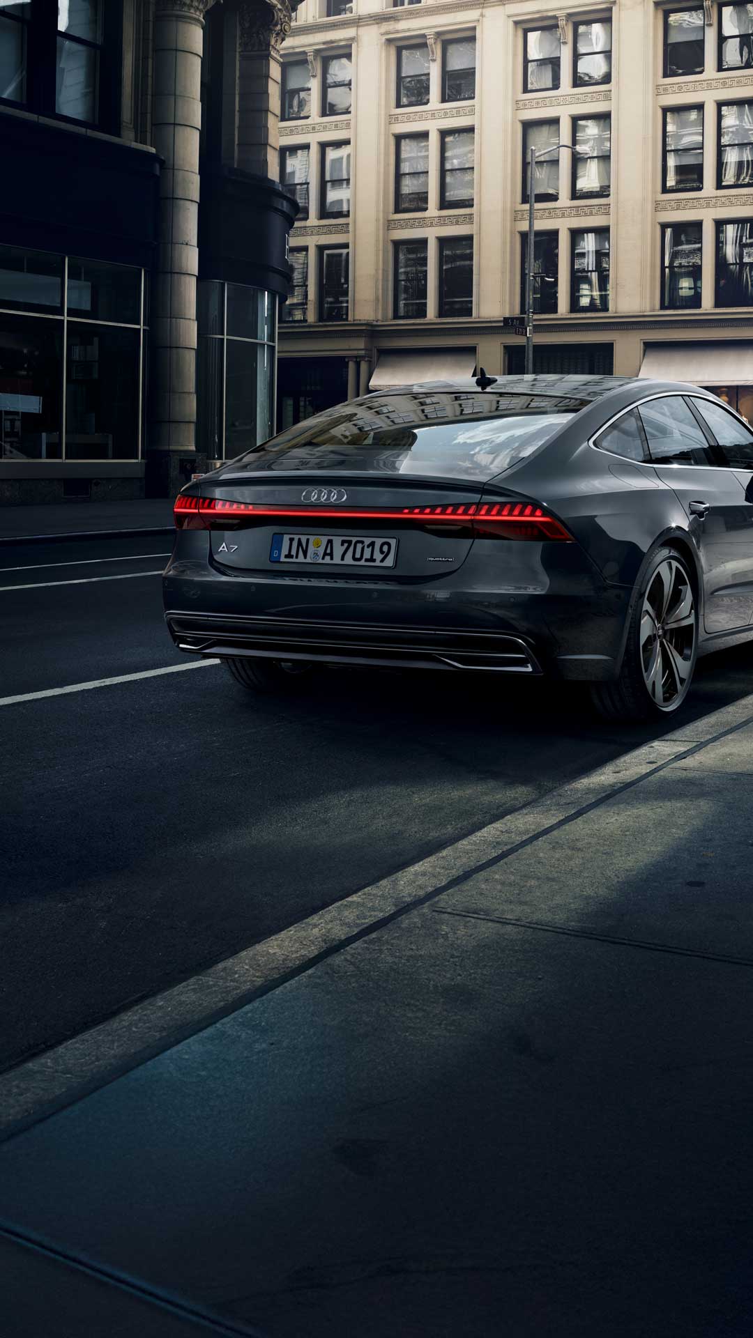 Side rear view of a gray Audi A7 Sportback in a urban street canyon