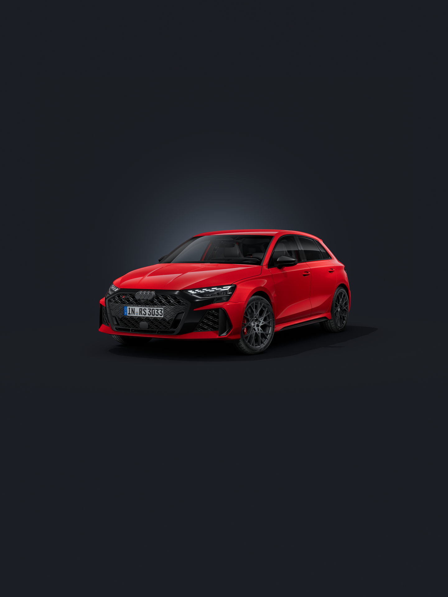 Der Audi RS 3 Sportback schräg von vorne auf dunklem Hintergrund.