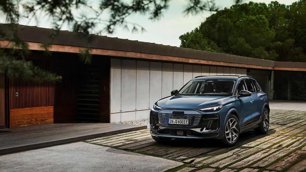 Audi Q6 e-tron parkerad utanför ett hus