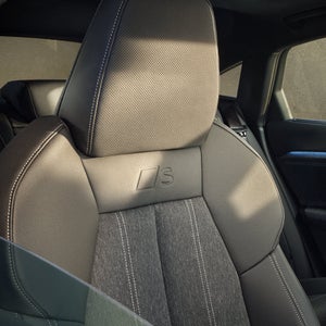 Nahaufnahme des Beifahrersitzes durch das halb geöffnete Beifahrerfenster.