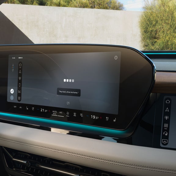 Close-up of the MMI touch display showing the Audi assistant interface.