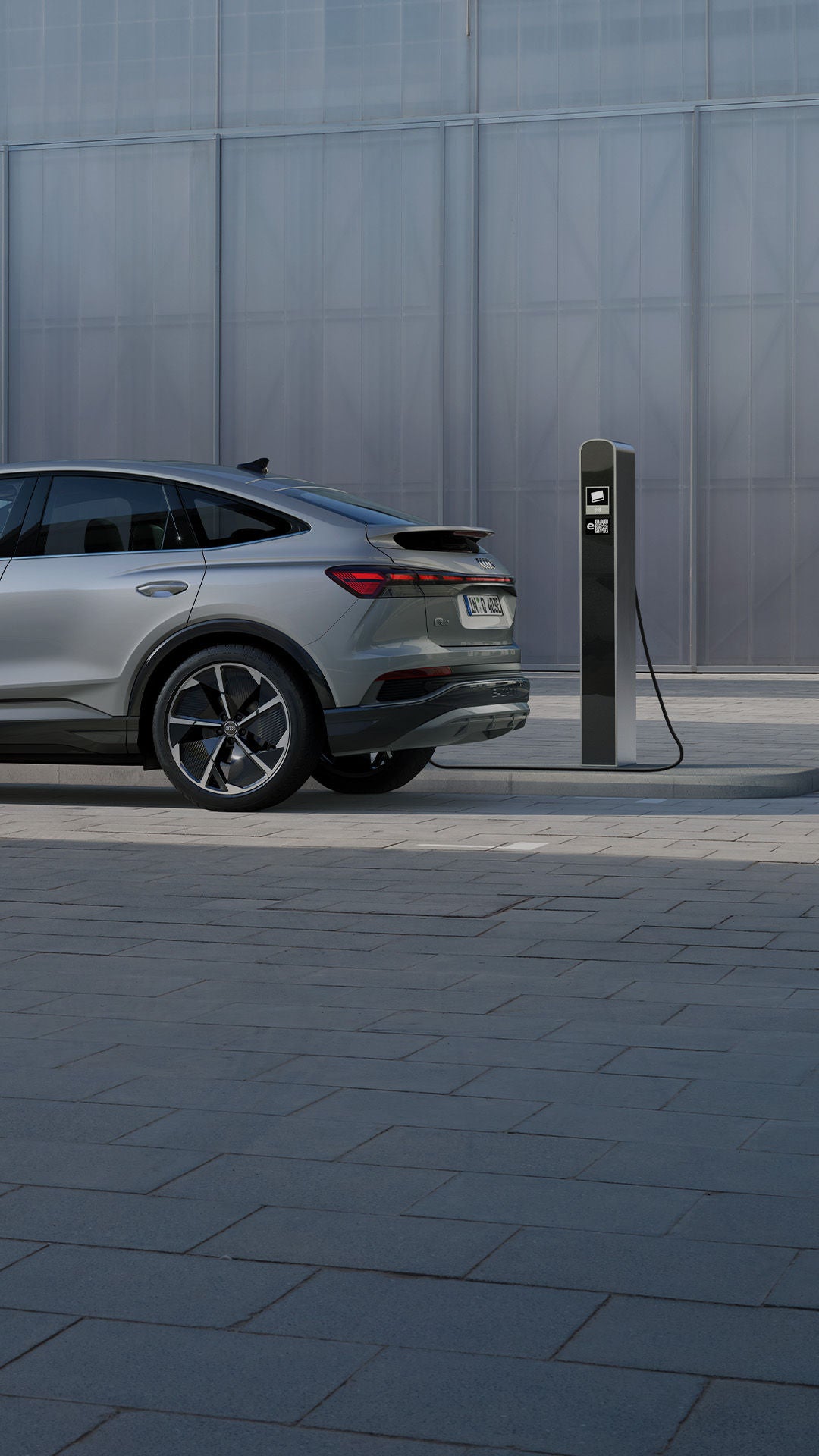 An Audi electric vehicle on charge in an urban setting