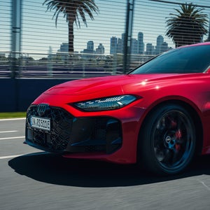 Ein Audi RS 5 Avant fährt auf einer Rennstrecke. Das vordere Drittel des Fahrzeugs ist von der Seite zu sehen.