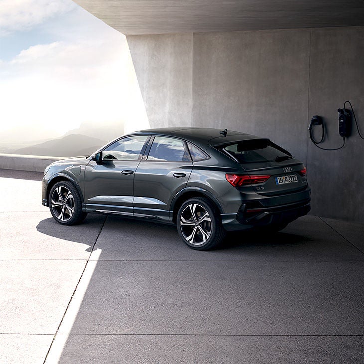 Foto de un coche SUV híbrido de Audi y las soluciones de carga eléctrica disponibles.