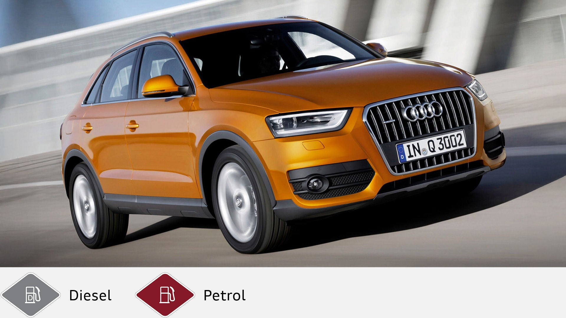 Orange Audi Q3 driving on the road in front of a light-colored concrete wall, front at a slight angle to the camera. Below gray diesel symbol and red gasoline symbol.