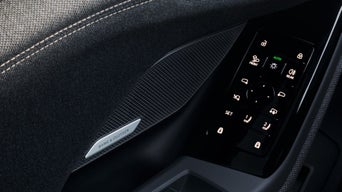 Car interior showing a Bang & Olufsen speaker and a sleek vehicle door control panel.