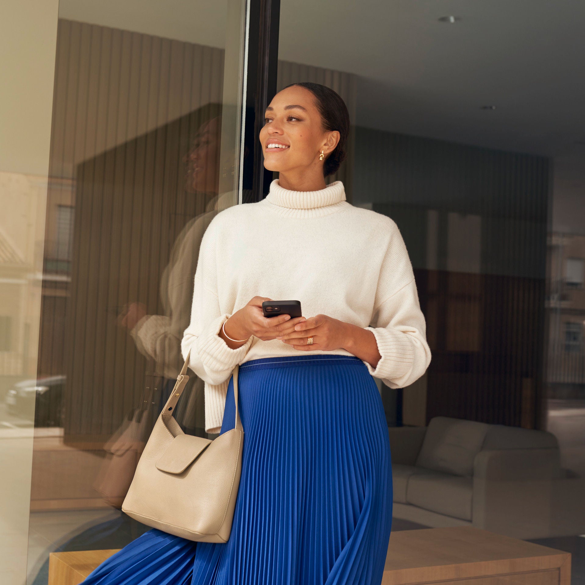 Een vrouw met eet blauwe jurk komt een deur uit.