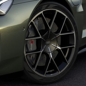 Detalhe da roda dianteira do Audi RS e-tron GT performance, com aro preto, pinça de freio RS e pintura verde fosca.