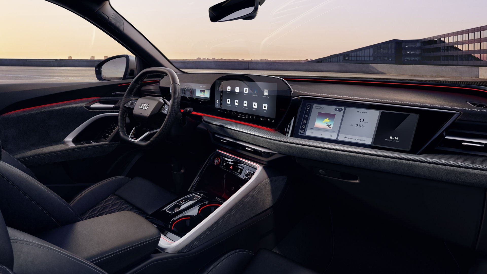 Zicht door het passagiersraam op de cockpit van de Audi SQ5 SUV. Onder meer het panoramadisplay, het MMI-display voor de passagier en de rode sfeerverlichting zijn zichtbaar.
