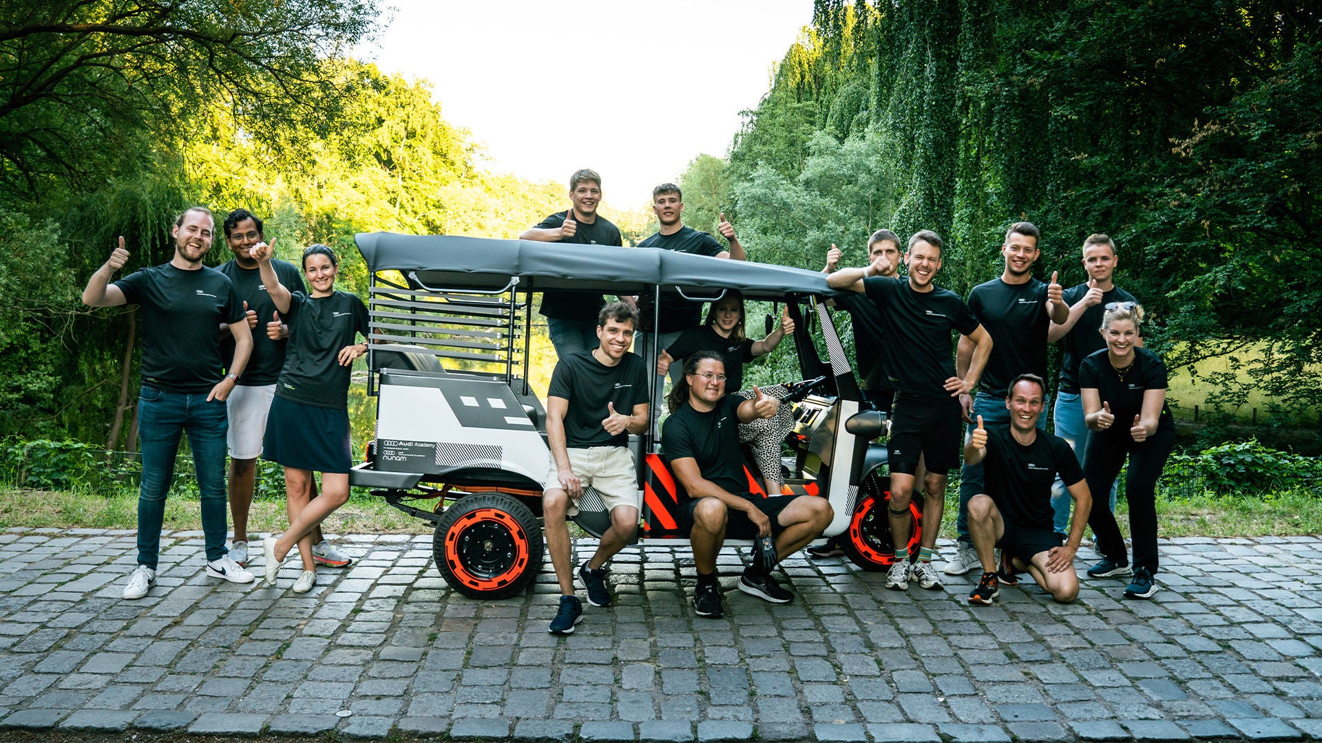 Menschen stehen und hocken vor einer E-Rikscha.