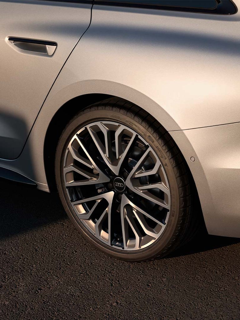 Detailansicht der hinteren Felge eines Audi A5 Avant mit markantem Felgendesign im Sonnenlicht.