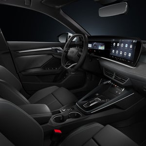 Blick von der Beifahrerseite auf das Cockpit mit Lenkrad, Mittelkonsole, digitale Displays und das Ambiente-Licht.