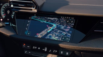 Frau blickt auf das digitale Navigationsdisplay im Audi-Lenkrad mit eingeblendeter Straßenkarte.