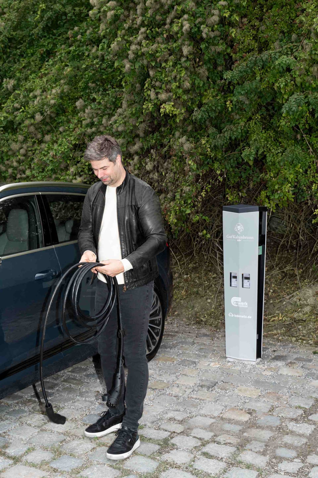 Nils Wollny portant un câble de chargement dans ses mains.