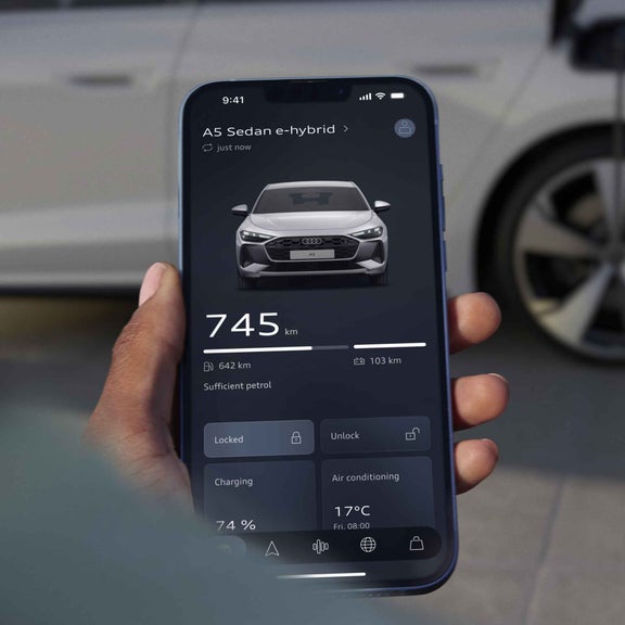 Närbild på en smartphone med Audi Charging-appen. Skärmen visar laddningsstatus, bränslenivå och aktuell räckvidd.