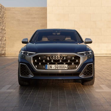 Frontansicht eines blauen Audi SQ8 SUV mit markantem Kühlergrill und LED-Scheinwerfern.