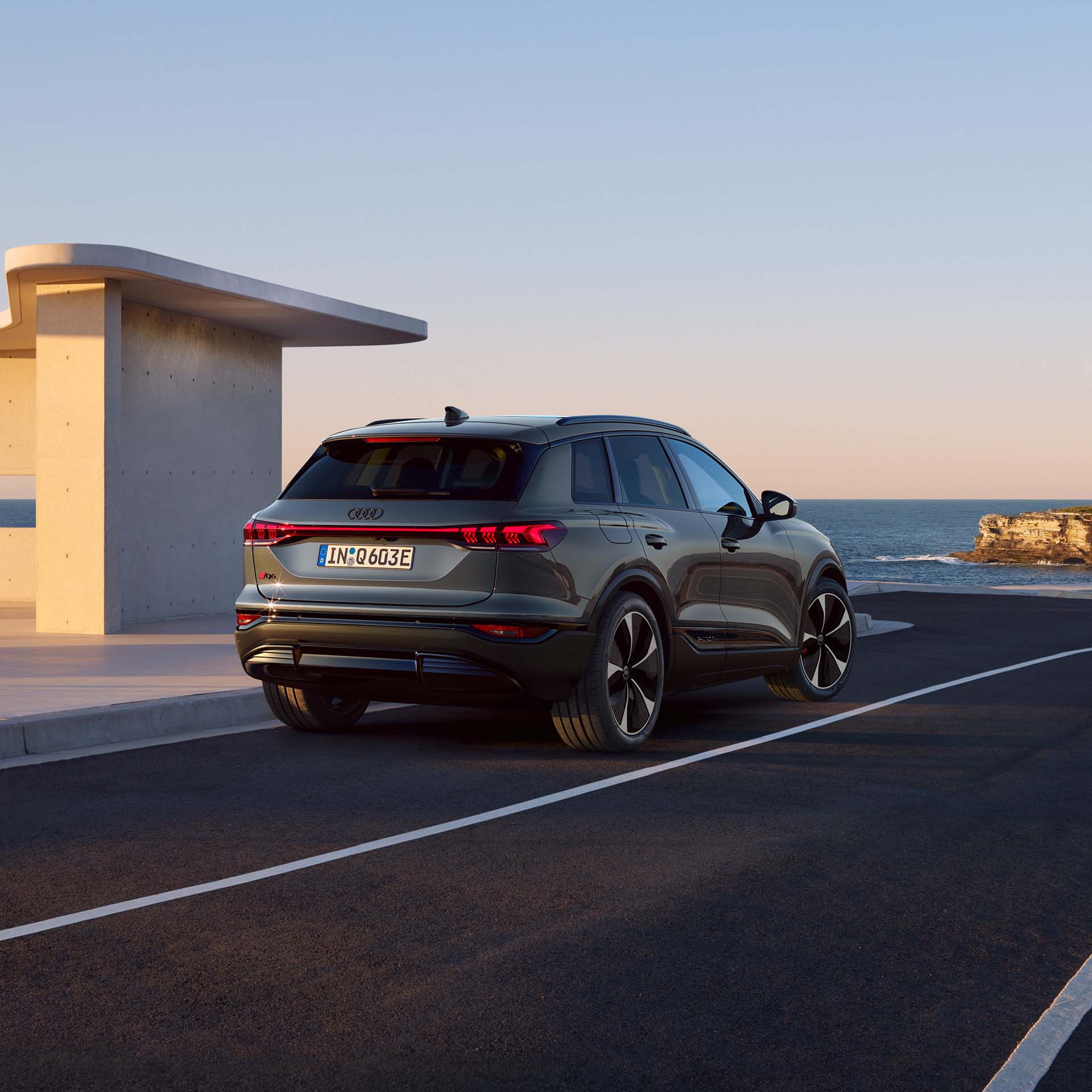 Vy bakifrån på nya Audi Q6 e-tron vid en laddstation.
